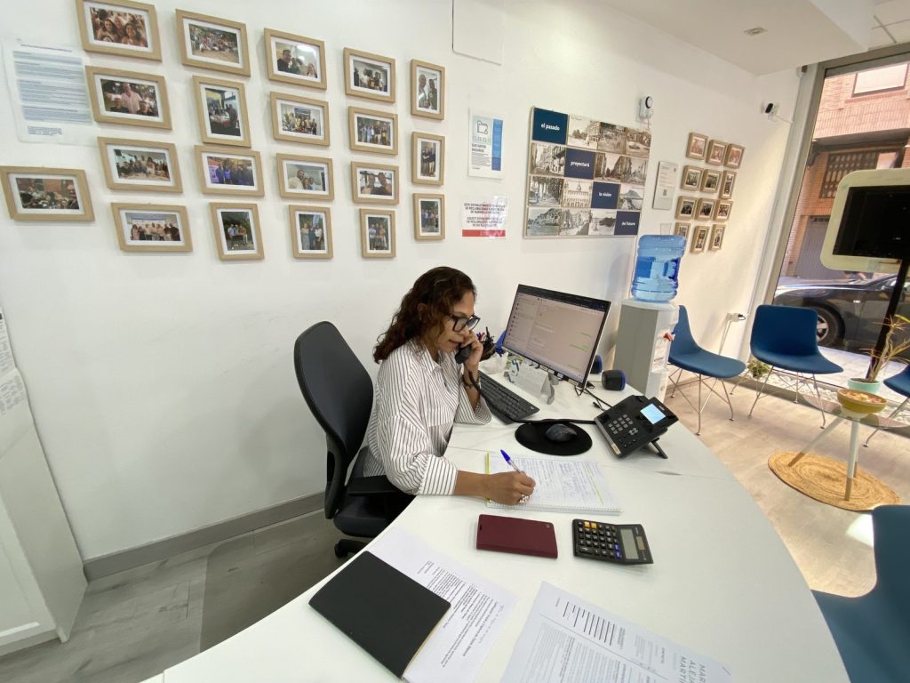 Reception of the Wereal Grupo Inmobiliario office in Alicante with an agent taking a call